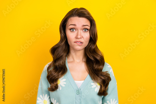 Photo of doubtful uncertain woman wear turquoise cardigan biting lip isolated yellow color background