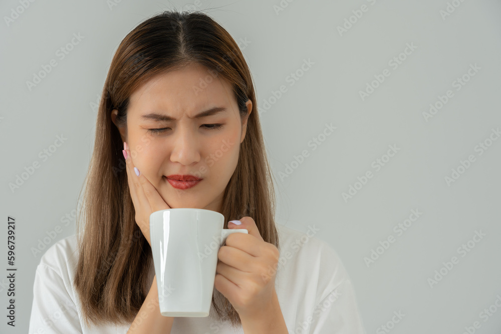 Asian woman feel sensitive teeth after drinking hot, female suffer tooth, decay problems, dental care, tooth extraction, decay problem, bad breath, Gingival Recession, Oral Hygiene instruction. Asian woman feel sensitive teeth after drinking hot, female suffer tooth, decay problems, dental care, tooth extraction, decay problem, bad breath, Gingival Recession, Oral Hygiene instruction.
