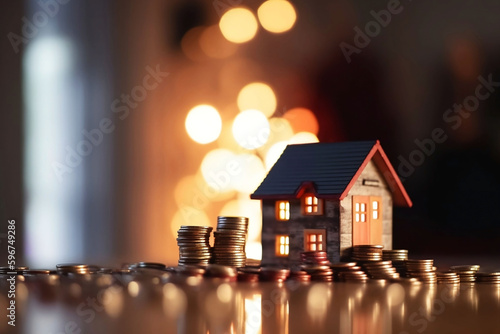 Model House and Stacked Coins on Table with Home Background for Product Display, Blurred Bokeh Interior Light Background, Ready for Investment and Business Growth Concept. Perfect for Product Montage