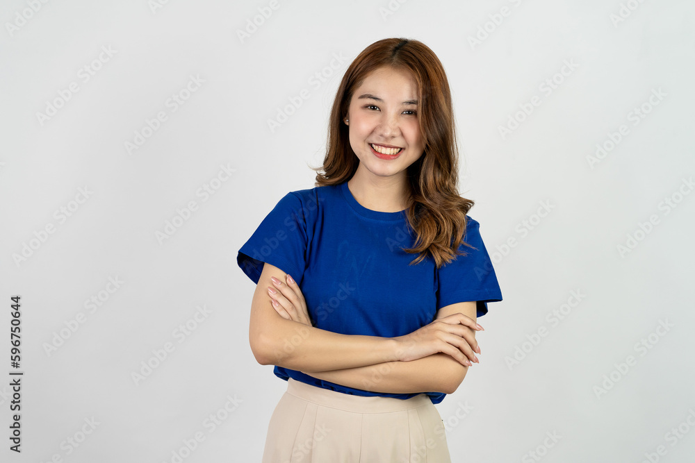 Obraz premium Happy Asian woman in blue t-shirt posing with hands and looking at camera on white background