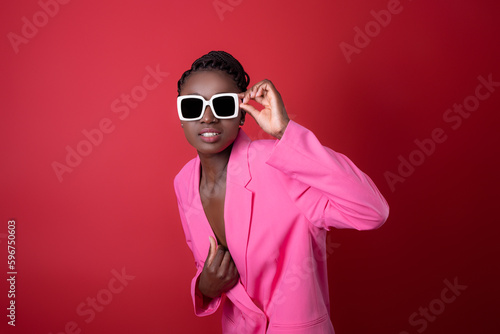 Fashion Shot Of Young Black Woman Wearing Pink Jacket And Stylish Sunglasses © Prostock-studio