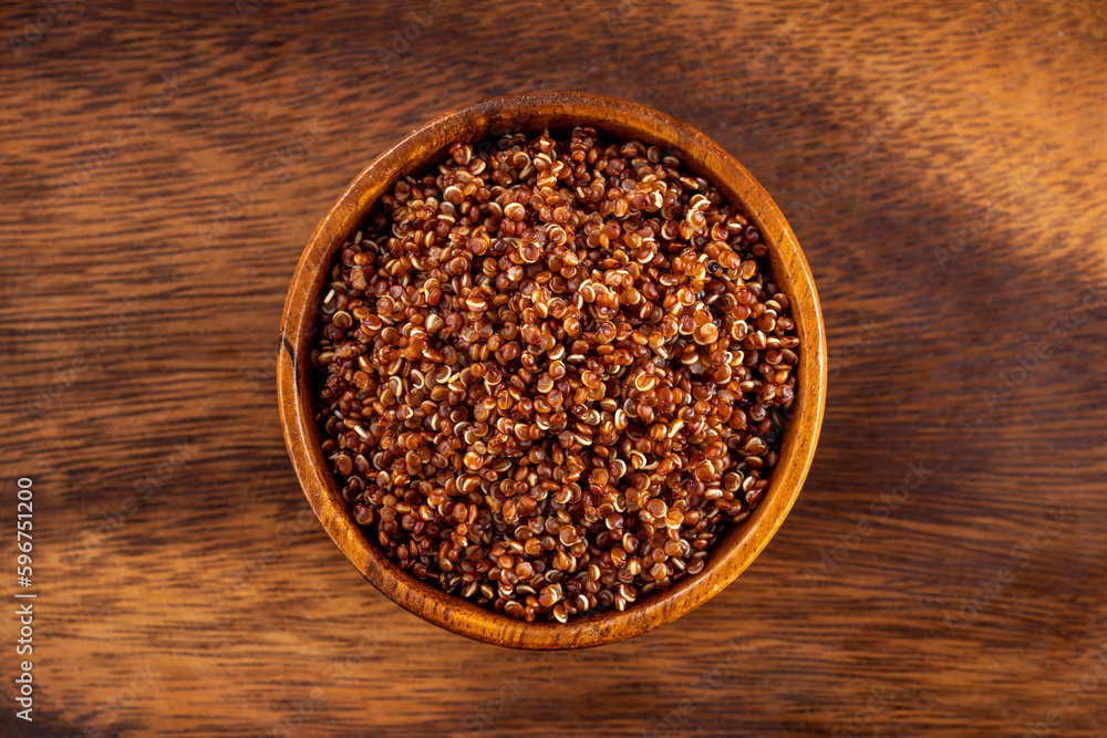 Cooked red quinoa bowl. Up view studio shoot on wooden background. Cooked red quinoa bowl. Up view studio shoot on wooden background.