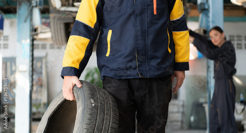 A car mechanic inspects the condition of a car tire before placing it on a vehicle.