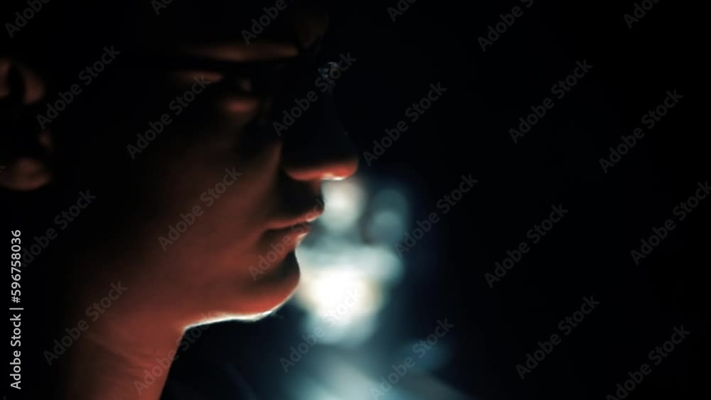 Close-up shot of a boy with a flame torch in his hand walking in the dark with some suspicious thing in the background. HD footage. Cinematic shot. Close-up shot of a boy with a flame torch in his hand walking in the dark with some suspicious thing in the background. HD footage. Cinematic shot.
