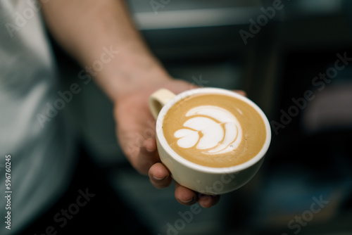 barista serving a customer hot coffee latte in a coffee cup in a cafe waiter preparing hot coffee with milk