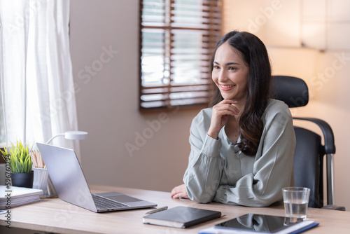 Young happy businesswoman working with tablet and mobile phone in corporate office.