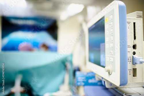 Monitor funkcji życiowych na sali operacyjnej widziany z boku, płytka głębia ostrości. © Tomasz
