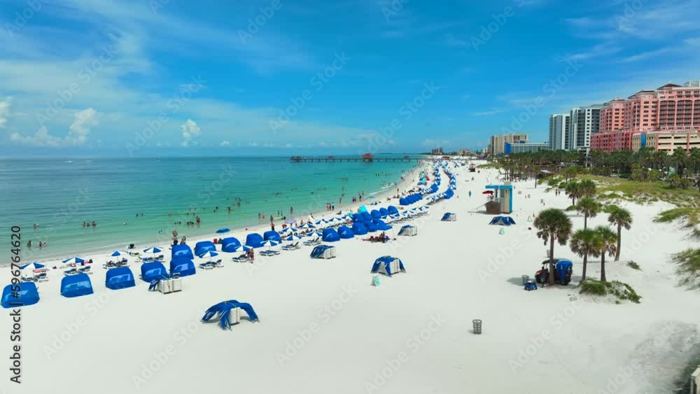 Beach lined with blue beach chairs and people enjoying summer. Beach lined with blue beach chairs and people enjoying summer.