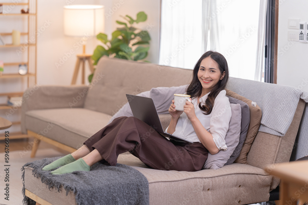 Full length photo of positive business girl sits floor legs crossed folded work remote laptop read document report hold mug beverage in house Full length photo of positive business girl sits floor legs crossed folded work remote laptop read document report hold mug beverage in house
