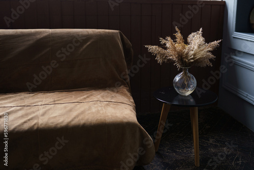 Dried flowers in vase on wooden table near old vintage vase