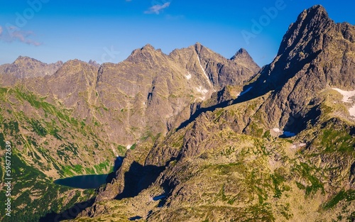 Mountain landscape in summer scenery. Picturesque view stretches over mountain ridge and high rocky summits in High Tatras, Poland.