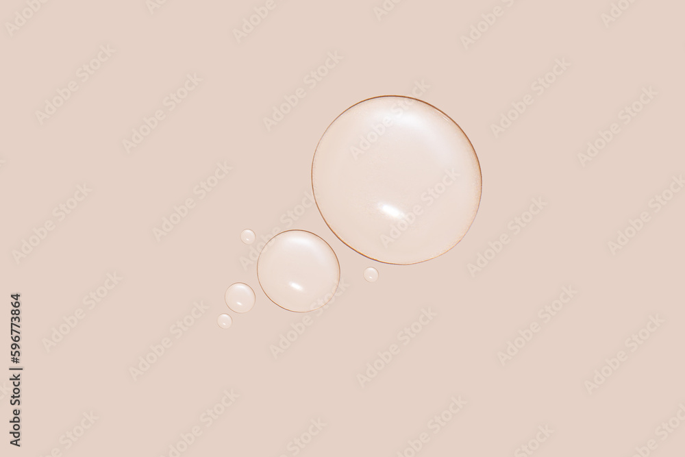 Drops of transparent gel or water in different sizes. On a beige background. Drops of transparent gel or water in different sizes. On a beige background.