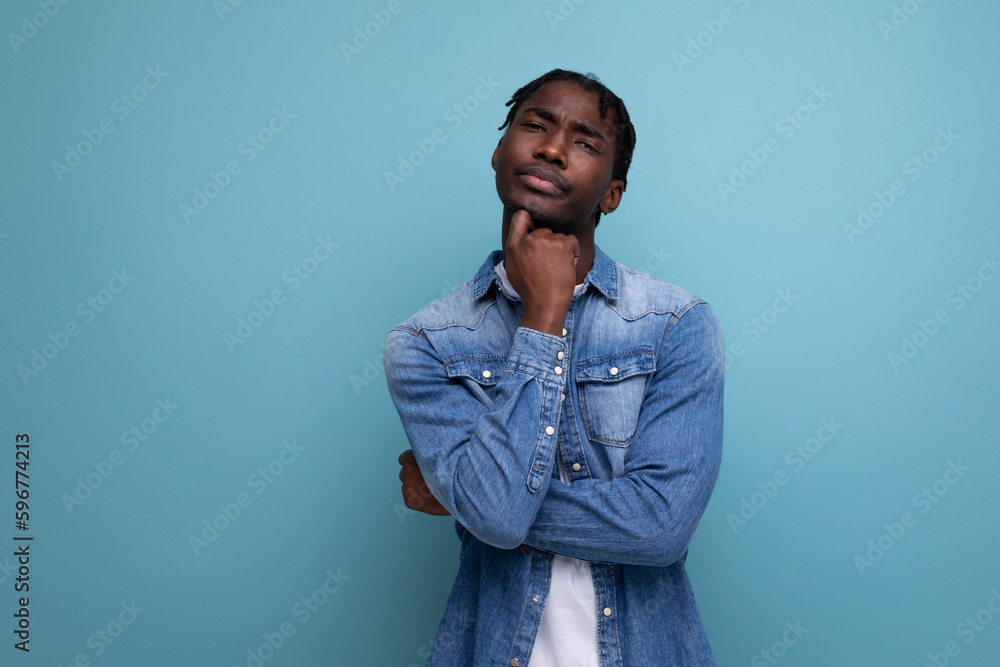 charismatic dude african man with curly hair in a denim jacket on a blue background charismatic dude african man with curly hair in a denim jacket on a blue background