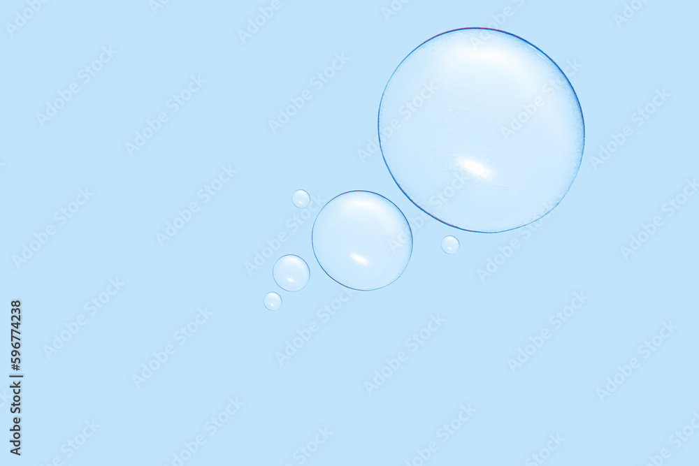 Drops of transparent gel or water in different sizes. On a blue background. Drops of transparent gel or water in different sizes. On a blue background.