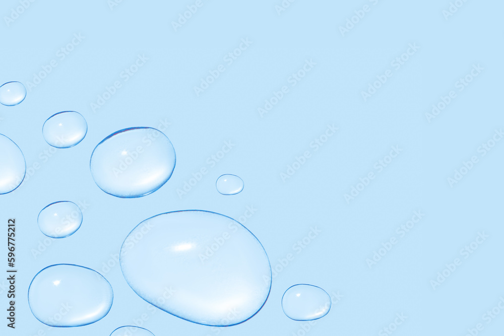 Drops of transparent gel or water in different sizes. On a blue background. Drops of transparent gel or water in different sizes. On a blue background.