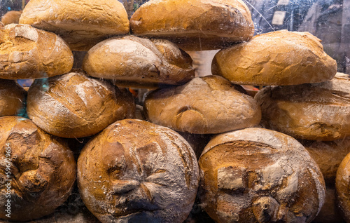 Lots of fresh hot freshly baked large round loaves of traditional rustic bread with flour on it, bakery, bread manufacture tradition, food industry simple abstract concept, nobody, no people, bread