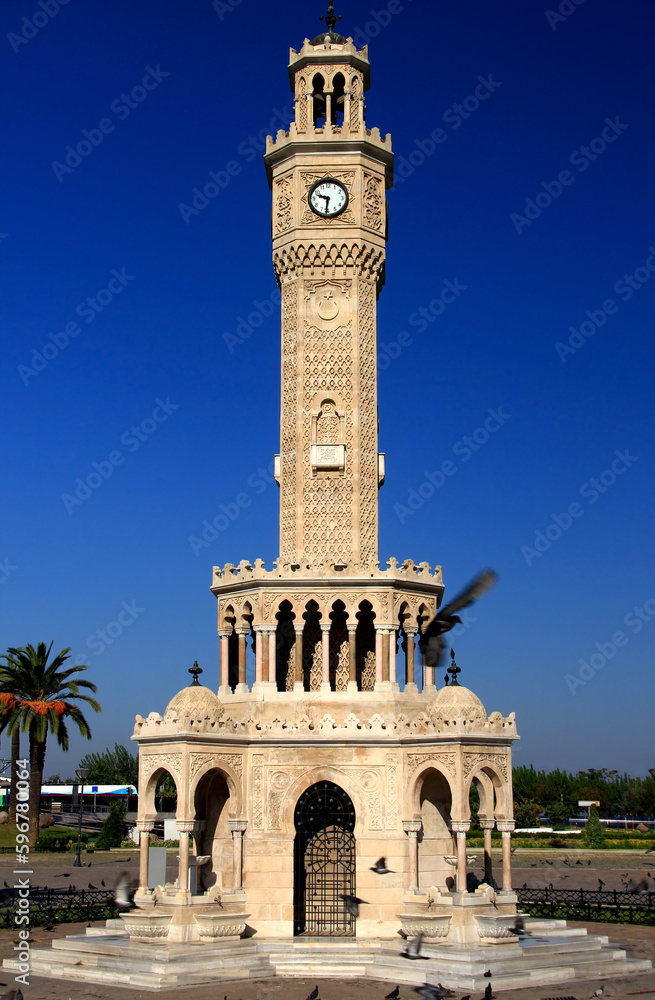 Photo of a view of the Konak Clock Tower with pigeons in the foreground in the historic center of Izmir, Turkey