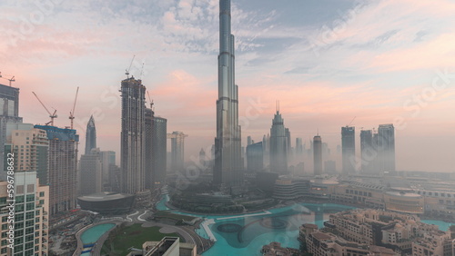 Aerial view of Dubai city early morning during fog night to day timelapse.