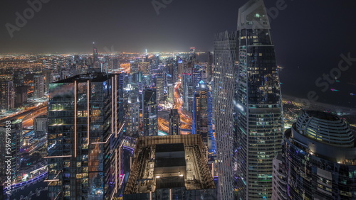 Panorama showing JBR district and Dubai Marina with JLT. Traffic between skyscrapers aerial night timelapse.