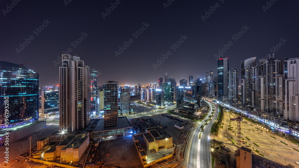 Water canal with modern towers residential development in Business Bay aerial panoramic all night timelapse, Dubai