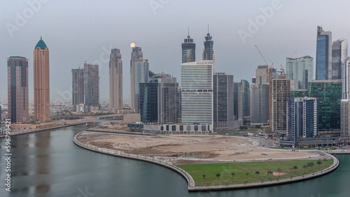 Cityscape of skyscrapers in Dubai Business Bay with water canal aerial night to day timelapse