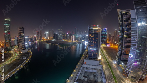 Cityscape panorama of skyscrapers in Dubai Business Bay with water canal aerial all night timelapse