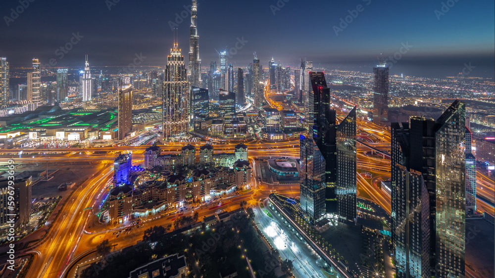Fototapeta premium Aerial view of tallest towers in Dubai Downtown skyline and highway day to night timelapse.