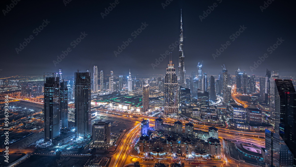 Obraz premium Panorama showing aerial view of tallest towers in Dubai Downtown skyline and highway night timelapse.