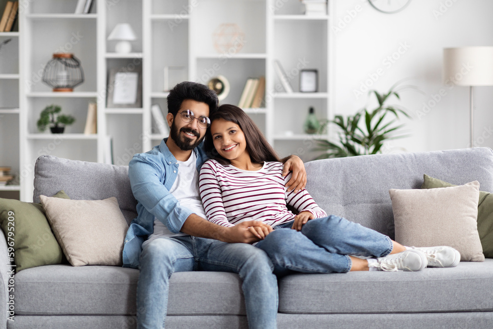 Obraz premium Cheerful young indian lovers enjoying time together at home