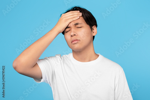 Sick Japanese Teen Guy Having Fever And Headache, Blue Background