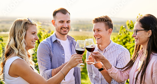 Young friends having fun outdoors - Happy people enjoying harvest time together at farmhouse winery countryside - Tasting red wine at vineyard © napeter