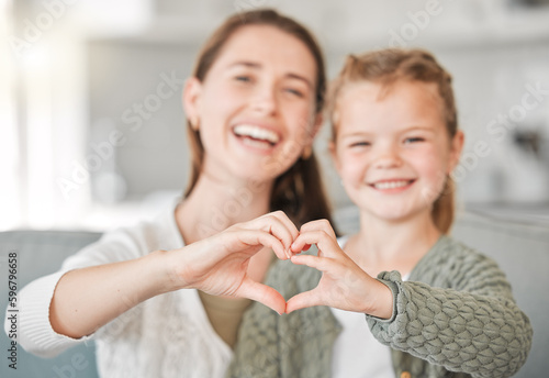 In truth  a family is what you make it. Shot of a mother and daughter making a heart sign with their hands at home.