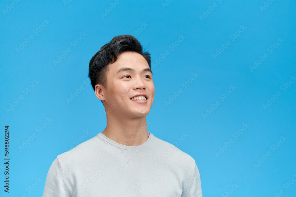 happy smiling young man looking up over blue