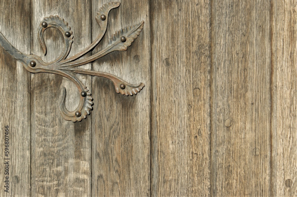 Fragment of an antique door with a fragment of a decorative hinge. Fragment of an antique door with a fragment of a decorative hinge.