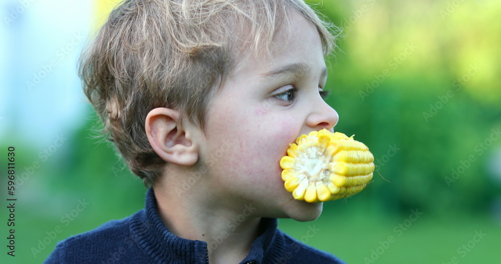 Happy infant toddler eating corn outside. Funny baby boy holding and eating healthy snack Happy infant toddler eating corn outside. Funny baby boy holding and eating healthy snack