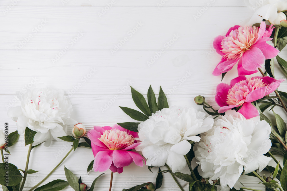 Pink and white peonies on a white wooden background, copy space, flat lay, greeting card.