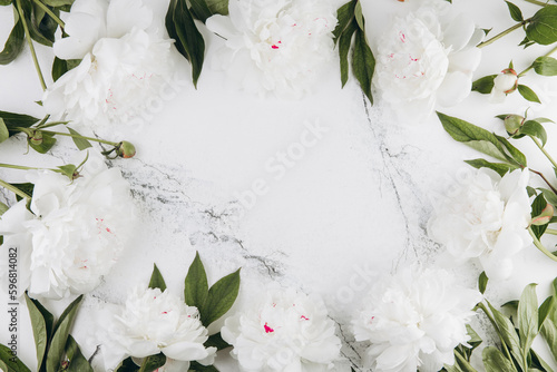 White peonies on a white marble background, copy space, flat lay, greeting card.