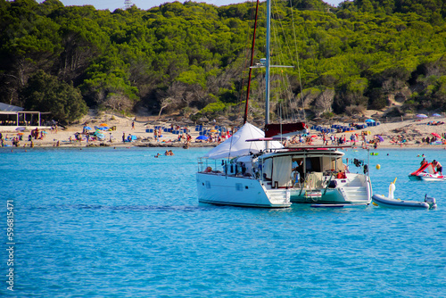 Catamaran anchored in the Mediterranean Sea in front of the beach of Cala Agulla on the eastern coast of Mallorca in the Balearic Islands, Spain photo