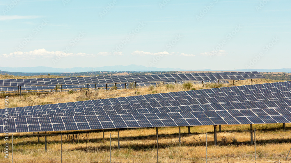 Photovoltaic solar panel farm with landscape background , green clean energy concept. Panoramic view of a modern solar farm of photovoltaic panels on a plot Photovoltaic solar panel farm with landscape background , green clean energy concept. Panoramic view of a modern solar farm of photovoltaic panels on a plot