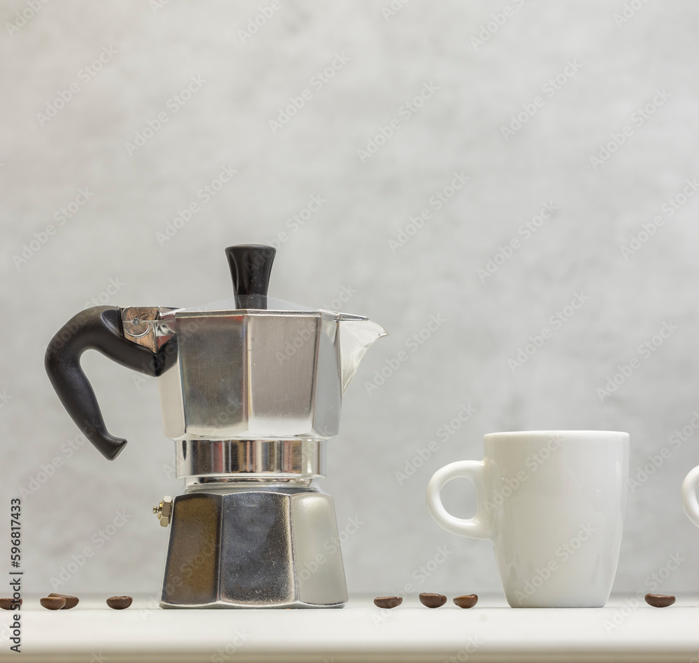 Metal geyser coffee maker on table with cup Metal geyser coffee maker on table with cup