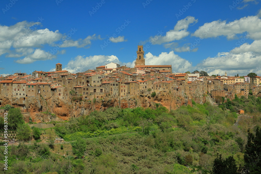 Panorama of the medieval small town of Pitigliano perched on a cliff on a clear April day.