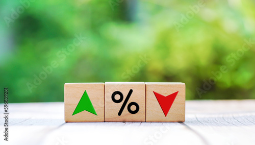 Interest rate financial and mortgage rates concept. Wooden cube block with icon percentage, symbol arrow up and down. on natural background.