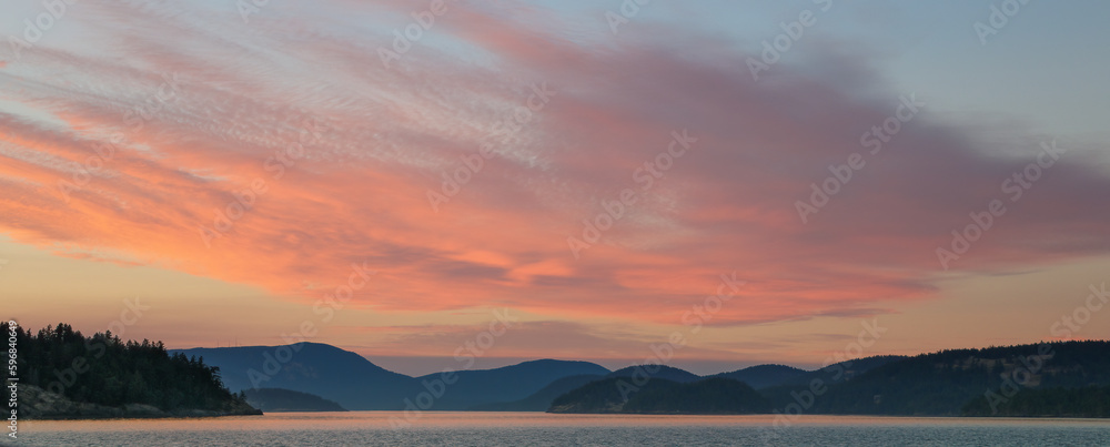 Sunset makes the clouds glow pink over the San Juan Islands as seen from Hunter Bay on Lopez Island.