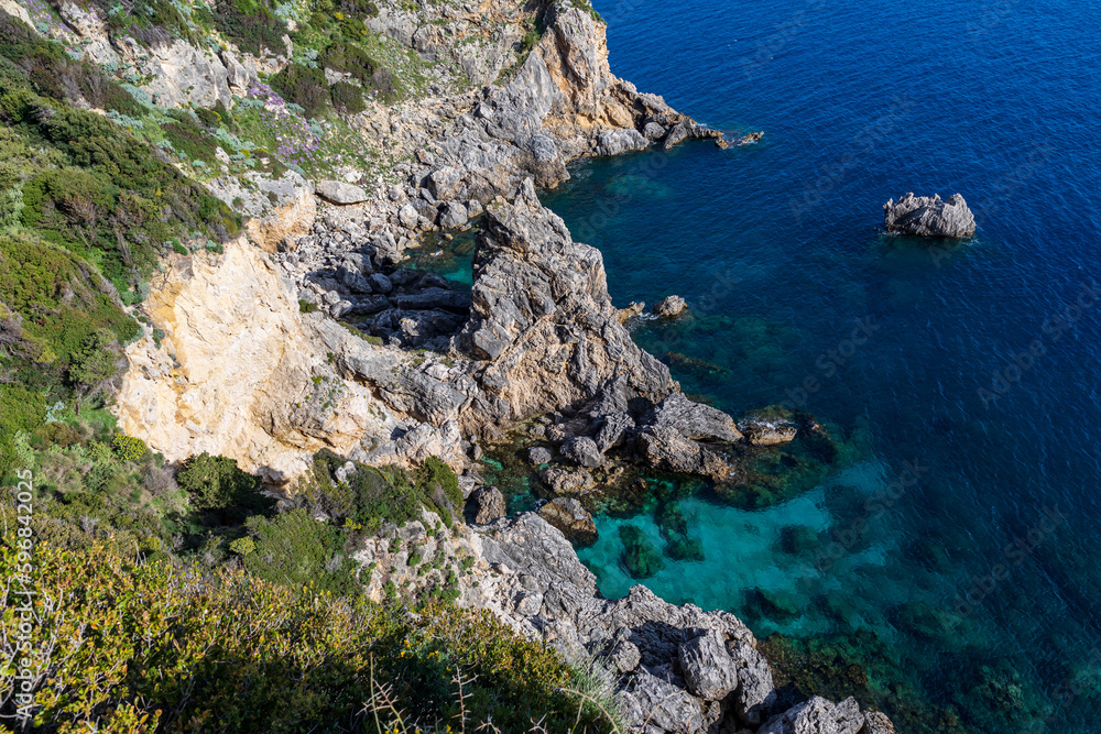 A beautiful landscape of the coast of the island of Corfu in the Ionian Sea of the Mediterranean in Greece. Pure blue clear water washes over the shores of the Greek island. A beautiful landscape of the coast of the island of Corfu in the Ionian Sea of the Mediterranean in Greece. Pure blue clear water washes over the shores of the Greek island.
