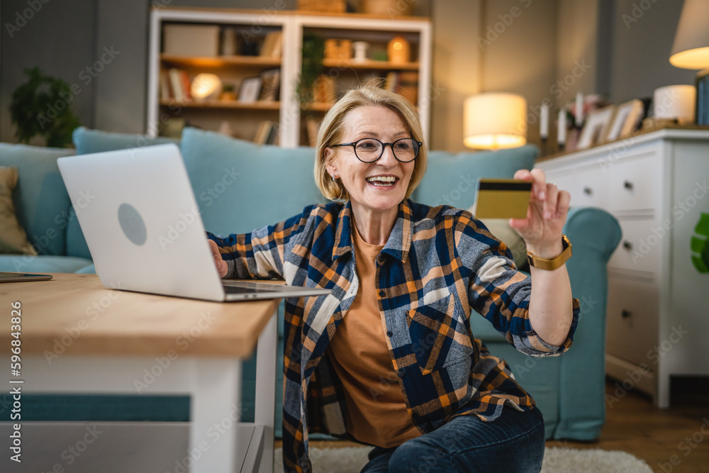 Senior woman caucasian female hold credit card online shopping at home Senior woman caucasian female hold credit card online shopping at home