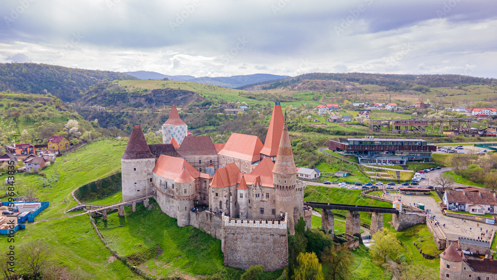 Aerial view of the Huniyad castle in Hunedoara, Romania in spring season, on a rainy day. Photography was shot from a drone at a lower altitude with the castle in the view. 