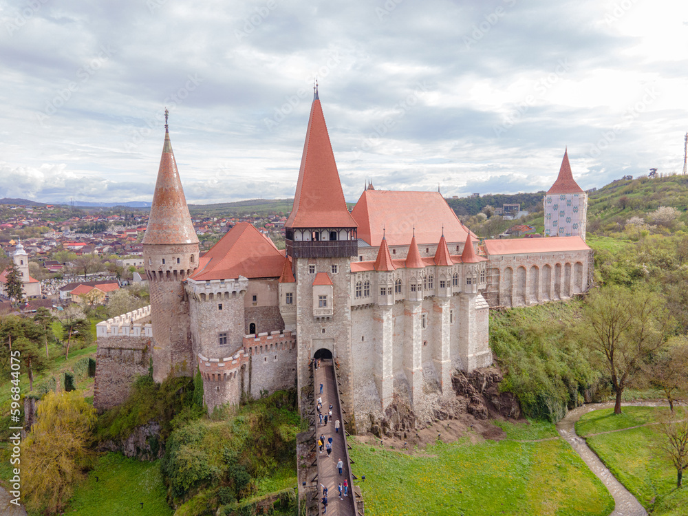 Aerial view of the Hunyad castle in Hunedoara, Romania in spring season, on a rainy day. Photography was shot from a drone at a lower altitude with the castle in the view. 