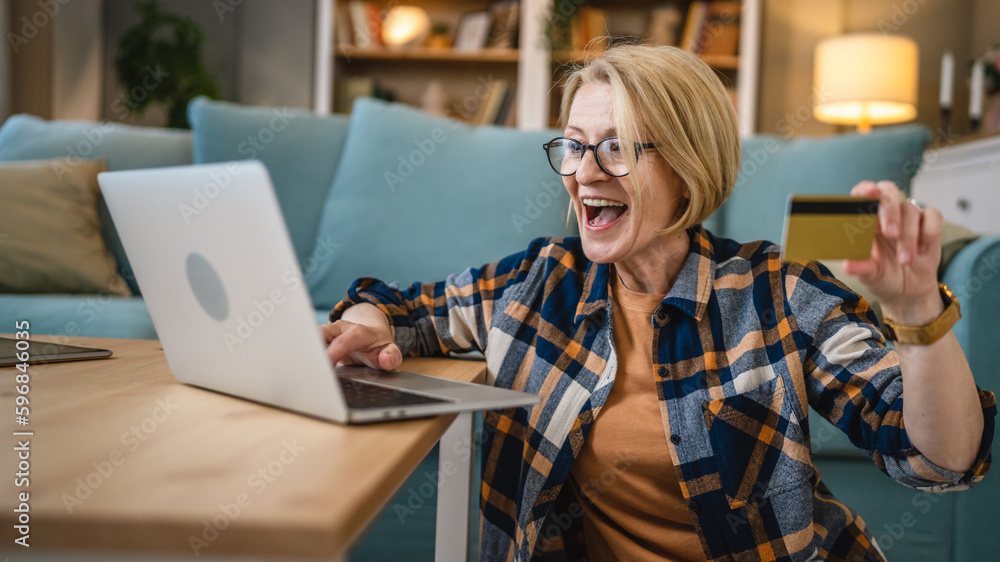 Senior woman caucasian female hold credit card online shopping at home Senior woman caucasian female hold credit card online shopping at home