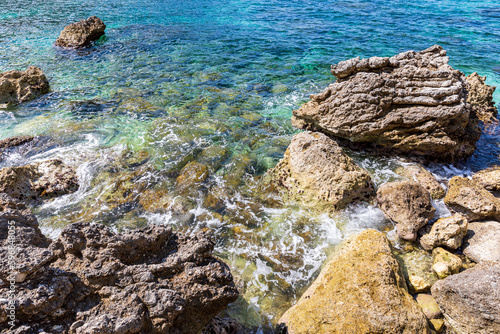 A beautiful landscape of the coast of the island of Corfu in the Ionian Sea of the Mediterranean in Greece. Pure blue clear water washes over the shores of the Greek island. © Volodymyr К