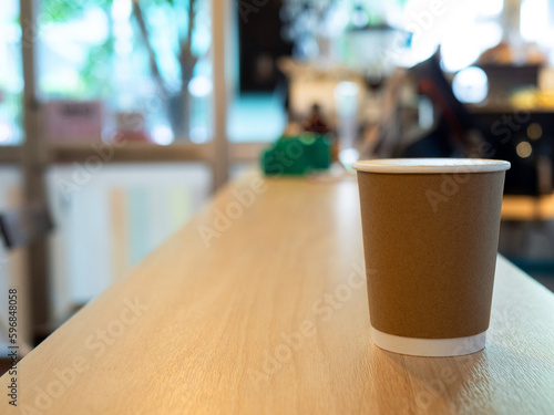 One Coffee cup paper placed on a wooden table, in a cafe coffee shop drinks are available. Hot inside for takeaway ready to drink, refreshing. aroma awake fresh to work placed